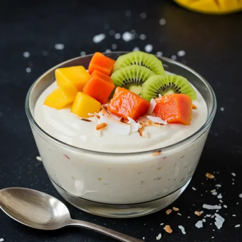 A creamy Coconut Milk Dessert served in a bowl, garnished with shredded coconut and a touch of mint, offering a tropical, dairy-free treat.