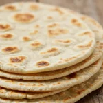 Homemade gyro bread, soft and fluffy with a golden-brown crust, perfect for wrapping gyro fillings.